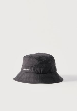 Pălărie tip bucket din țesătură neagră, cu margine cusută și mic logo alb „ARKK” pe lateral, pe un fundal simplu și luminos.