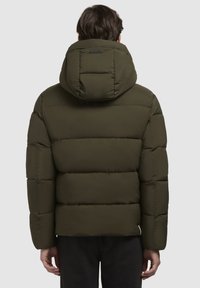 Olivegrøn nylon pufferjakke med hætte, der har quiltede sektioner, en glat tekstur og et lille label på ryggen til branding.