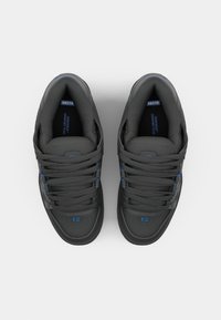 Black sneakers with blue accents, made of smooth leather, featuring a low-top design, flat laces, cushioned collars, and rubber soles.