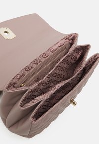 Borsa in pelle trapuntata blush con chiusura in oro, dotata di tre scomparti interni e fodera in tessuto decorato.