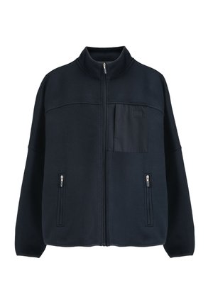 Marineblaue Fleecejacke mit hohem Kragen, Reißverschluss vorne, zwei seitlichen Reißverschlusstaschen und einer Patchtasche, ausgestattet mit einem strukturierten Stoff und minimalistischem Design.