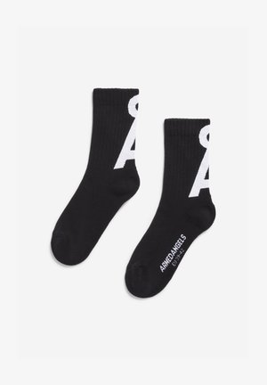 Calze nere con texture a righe, caratterizzate dal logo bianco "A" sui lati e dal testo "ARHEDANGELS" sulla suola. Lunghezza standard alla caviglia.