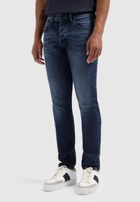 Mannen's donkerblauwe spijkerbroek met een slim fit, met lichte verkleuring, standaard vijf-pocketontwerp en een knoopsluiting.