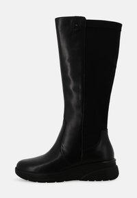 Stivale da donna alto in pelle nera e tessuto con suola spessa e punta rotonda, visto di lato su uno sfondo bianco.