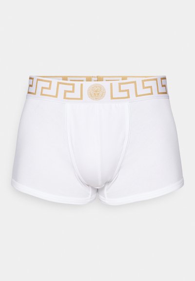 White cotton boxer shorts featuring a gold Greek key patterned waistband with a central logo. Smooth texture and tailored fit.