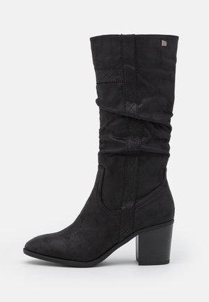 Zwarte suède kniehoge laarzen met een slouchy ontwerp, puntige neus en blokhak. Kenmerkt decoratieve stiksels langs de zijkanten.