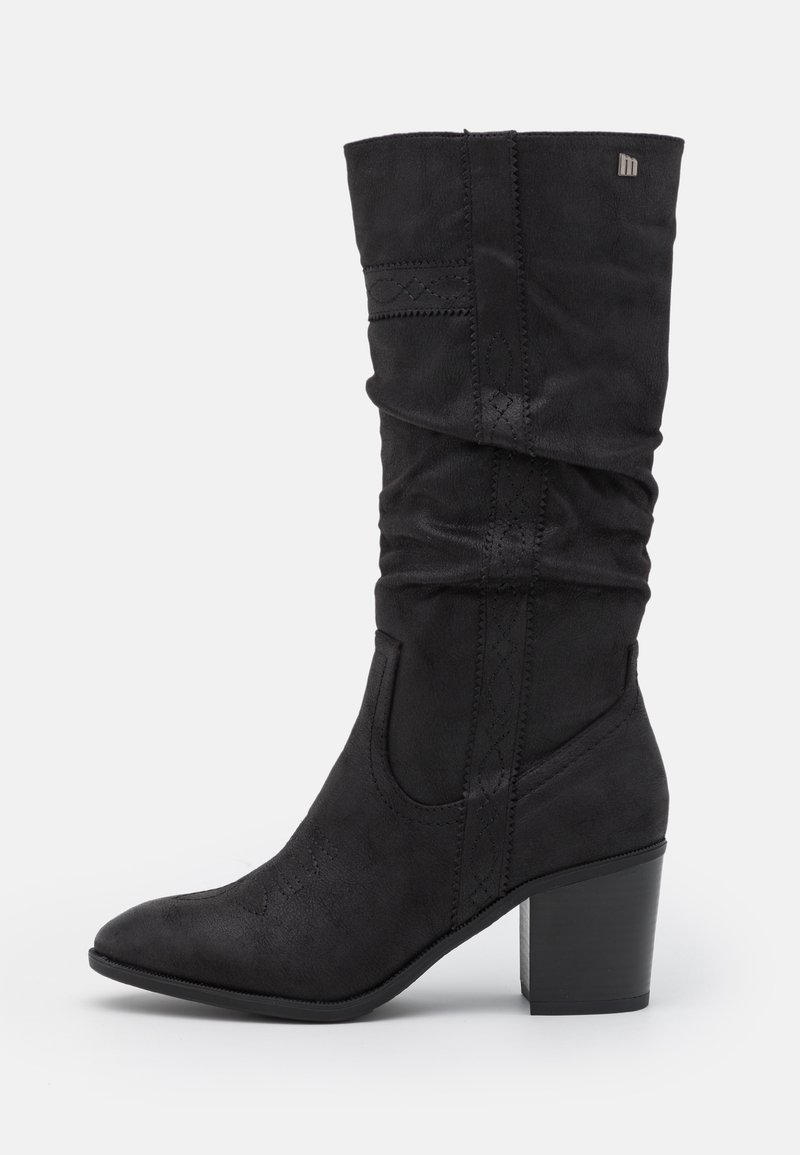 Bota de ante negra hasta la rodilla con diseño holgado, punta afilada y tacón ancho. Presenta costuras decorativas a lo largo de los laterales.