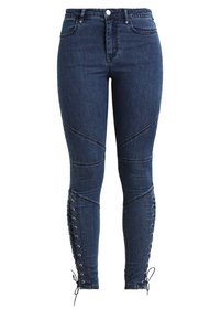 Tmavě modré úzké džíny s vysokým pasem, s šikmými švy a šněrovacími detaily na spodní části nohavic.