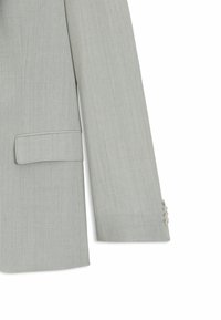 Jasnoszary blazer z teksturowanej tkaniny, z klapami, pojedynczą kieszenią na piersi oraz detalami mankietów z trzema guzikami.