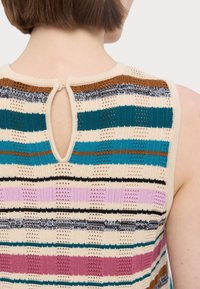 Haut sans manches en tricot à rayures beige, avec des fils turquoise, rose, noir et marron. Dos ouvert avec un détail en trou de serrure et un design texturé.