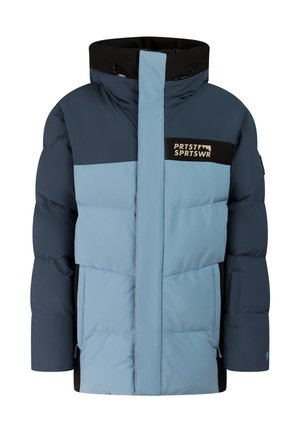 Kind trägt blaue und schwarze Winterjacke, passende Hose, schwarze Handschuhe und Stiefel sowie eine gestreifte blaue Strickmütze und steht vor einfarbigem Hintergrund.