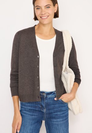 Bruine gebreide cardigan met een v-hals, vijf knopen en geribde manchetten. Draag het over een wit T-shirt, gecombineerd met een blauwe spijkerbroek en een fluffy tas.