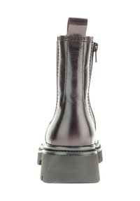 Bottine en cuir marron châtaigne avec une fermeture éclair arrière, une languette de tirage et une semelle en caoutchouc noir épaisse. Texture lisse et détails en couture.