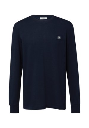 Chemise à manches longues bleu marine avec col rond, tissu subtilement texturé et petit logo rectangulaire sur la poitrine gauche.