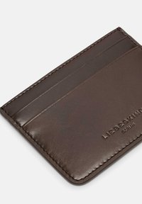 Brązowy skórzany portfel na karty z czterema przegródkami, tłoczonym logo i gładką fakturą. Charakteryzuje się precyzyjnym przeszyciem wzdłuż krawędzi.