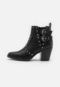 Black ankle boots with a pointed toe, featuring a textured leather material, silver studs, and two buckle accents on the side.