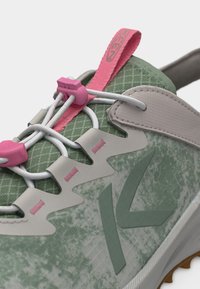 Πράσινο και γκρι αθλητικό παπούτσι με ροζ χειρολαβή και κουμπώματα, διαθέτει ελαστικά λευκά κορδόνια και υφασμάτινη υφή με σχεδιασμό.
