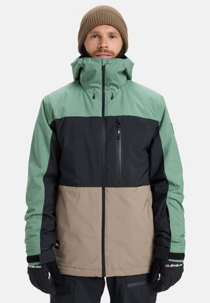 Herren Farbkombination Jacke in Minzgrün, Schwarz und Beige. Hergestellt aus wasserdichtem Material mit hohem Kragen und Reißverschluss-Brusttasche.