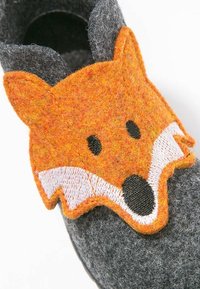 Gray felt shoe featuring an orange fox face appliqué with black details. The shoe has a rounded shape and a soft, textured surface.