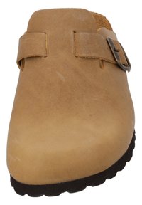 Tan clogs made of suede with a rounded toe, adjustable buckle strap, and textured black rubber sole. Soft inner lining visible.