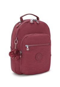 Bordeaux nylon rugzak met een afgerond ontwerp, een voorzak met rits en een fluffy aap sleutelhanger bevestigd. Heeft een logo patch aan de voorkant.
