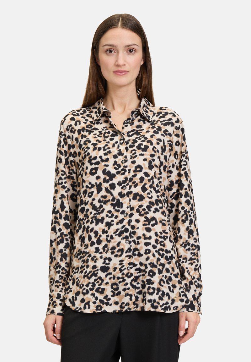 Leopardenmuster-Hemd mit Knöpfen aus weichem Stoff, mit langen Ärmeln, spitzem Kragen und relaxed Fit. Schwarz- und Brauntöne dominieren das Muster.