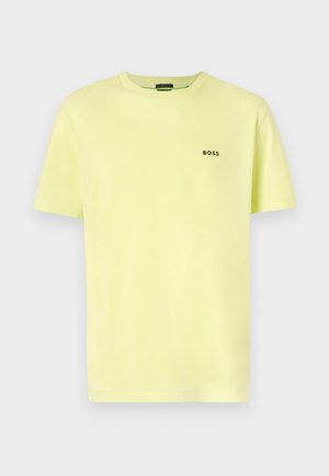 T-shirt di cotone giallo chiaro con collo rotondo classico, maniche corte e logo nero "BOSS" sul lato sinistro del petto. Texture liscia.