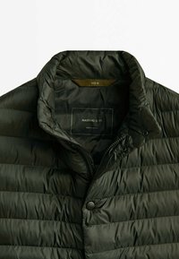 Veste matelassée vert foncé avec col montant, partiellement zippée et boutonnée, taille moyenne, étiquette indiquant Massimo Dutti, fabriquée au Vietnam.