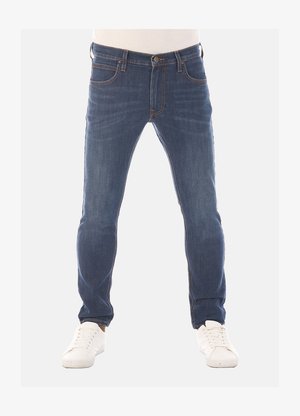 Donkerblauwe denim jeans met een slim fit, vijf-pocket ontwerp en contrasterende stiksels. Gecombineerd met witte sneakers.