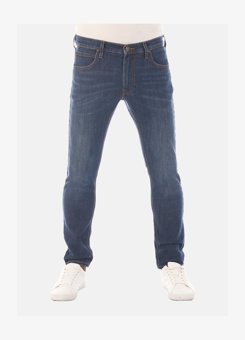 Donkerblauwe denim jeans met een slim fit, vijf-pocket ontwerp en contrasterende stiksels. Gecombineerd met witte sneakers.