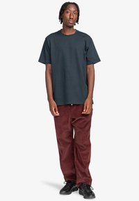 Mørkeblå bomulds t-shirt med korte ærmer og rund halsudskæring, parret med bordeaux corduroy bukser og sorte sneakers. Casual pasform.