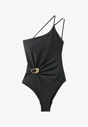 Maillot de bain noir asymétrique avec bretelles fines et détail boucle ovale dorée sur la taille froncée côté.
