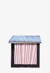 Illuminante in polvere in un compatto quadrato con un coperchio metallico viola. L'interno presenta un motivo a strisce rosa e beige con una texture luminoso.