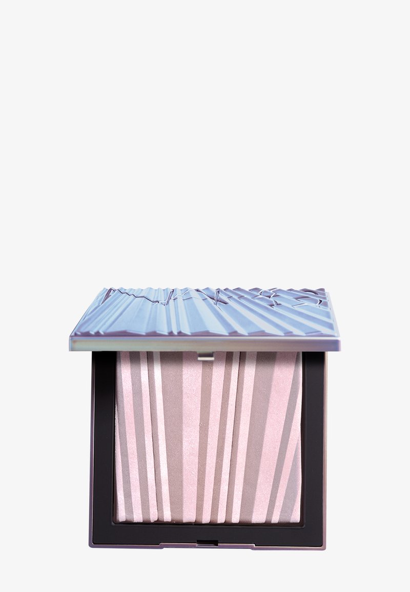 Illuminante in polvere in un compatto quadrato con un coperchio metallico viola. L'interno presenta un motivo a strisce rosa e beige con una texture luminoso.