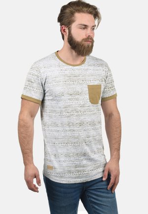 Kortærmet t-shirt i hvid og olivengrøn med et tekstureret mønster, rund halsudskæring og en lille brystlomme lavet af kontraststof.