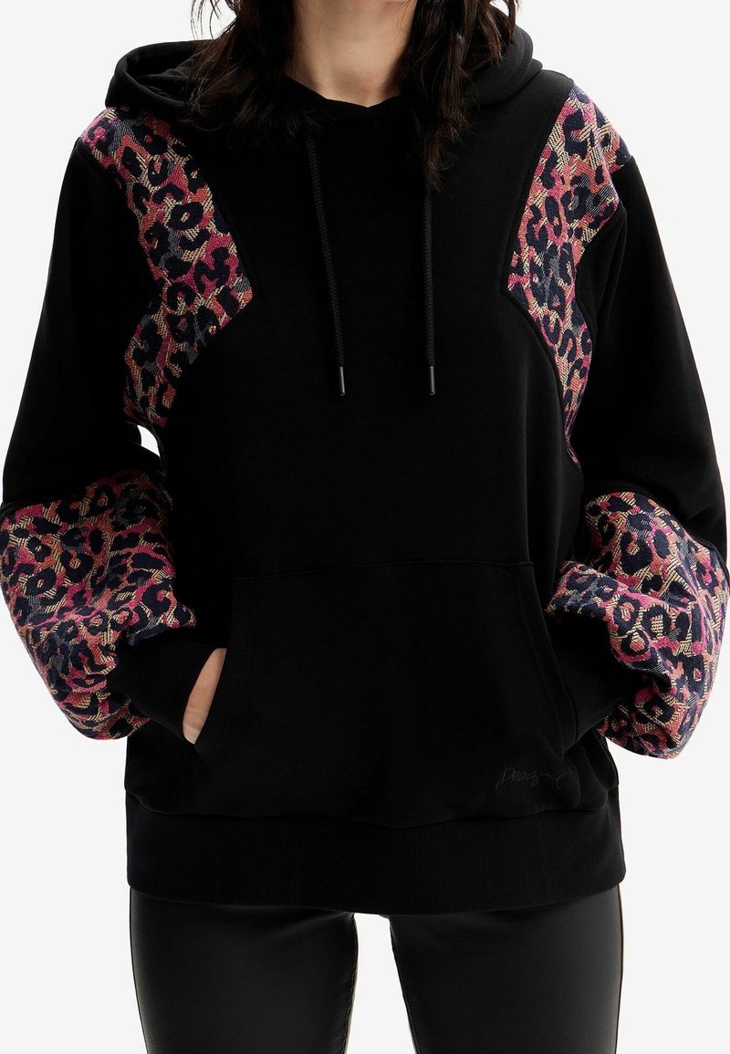 Sweat à capuche noir avec manches à motifs imprimé léopard rose et violet, cordon de serrage ajustable et poche kangourou à l'avant.