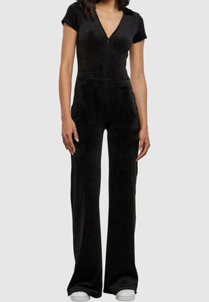 Musta haalarimekko, joka on valmistettu pehmeästä kankaasta. Siinä on vetoketj Closure, lyhyet hihat, syvä V-pääntie ja leveät lahkeet.