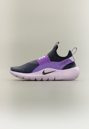 Chaussure de sport noire et violette à enfiler, avec une semelle blanche mouchetée, le logo Nike swoosh et le texte "Just Do It" sur la sangle latérale.