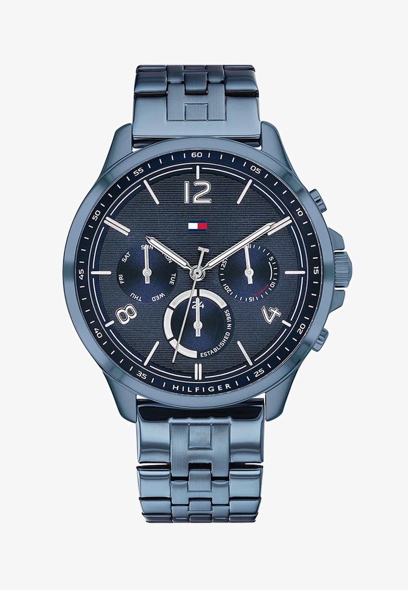 Blå metal armbåndsur med en struktureret mørkeblå urskive, sølv time markører, chronograf sub-ure og et armbånd i rustfrit stål.