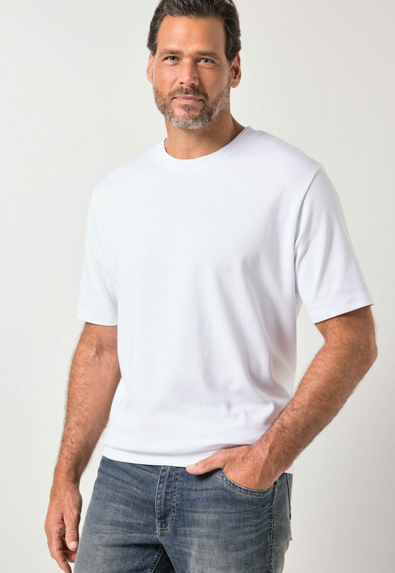 T-shirt blanc à manches courtes en coton avec un col rond, associé à un jean denim bleu. Design simple, texture lisse et coupe ajustée.