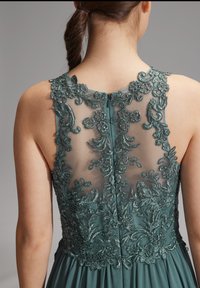 Abito teal con intricati ricami floreali e perline su un pannello posteriore trasparente, con un design di gonna liscia e fluente.