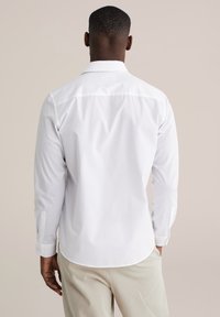 Wit shirt met lange mouwen van gladde stof, voorzien van een button-down kraag, ronde zoom en manchetten met een enkele knoopsluiting.