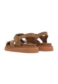 Brown suede sandals with an open toe, crisscross straps, and a thick textured sole. Backheel support and a smooth inner lining.