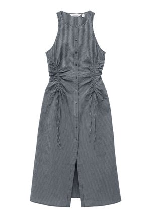 Robe sans manches longueur genoux avec rayures verticales noires et blanches, boutonnée sur le devant, côtés froncés avec liens et une fente à l'avant.