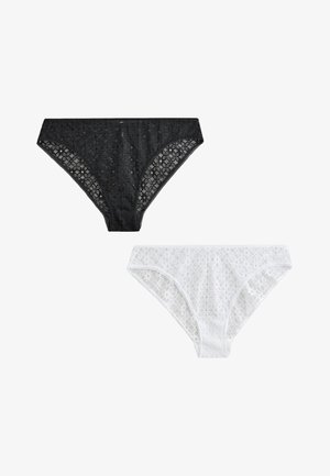 Dwie koronkowe majtki bikini, jedna czarna i jedna biała, wyświetlone obok siebie na białym tle.