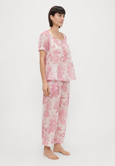 Conjunto de pijama com padrão floral rosa, apresentando uma blusa de corte solto com mangas curtas e calças com cintura elástica, feito de tecido suave.