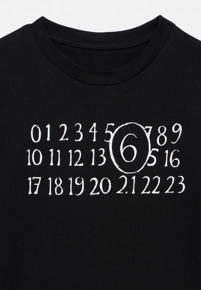 Zwart T-shirt met witte cijfers 0 tot 23 in drie rijen, het cijfer 6 is groter en omlijnd in het midden.