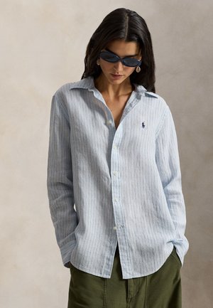 Ανοιχτό μπλε πουκάμισο με ριγέ μοτίβο και κουμπιά, με μακριά μανίκια, φτιαγμένο από απαλό ύφασμα. Διαθέτει μικρό λογότυπο στο στήθος και κλασικό γιακά.