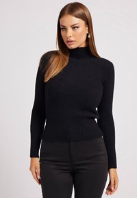 Maglione nero a collo alto a coste con maniche lunghe, realizzato in materiale a maglia testurizzato, design aderente e orlo sottile.