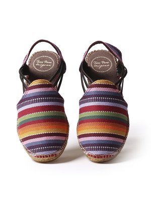 Espadrilles rayées colorées en tissu tissé, avec une semelle en jute et des brides élastiques à la cheville pour un maintien sécurisé.